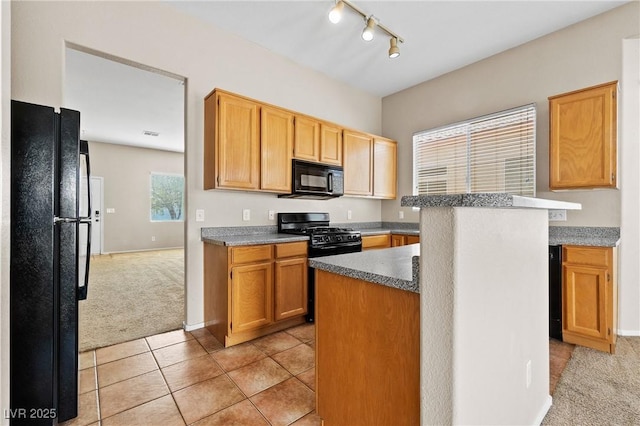 5307 Wild Orchid St, North Las Vegas, NV 89031 - kitchen with black appliances, light colored carpet, rail lighting, light tile patterned floors, and baseboards