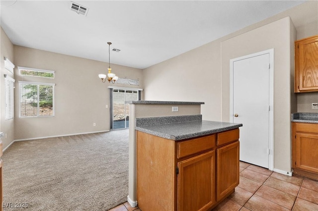 5307 Wild Orchid St, North Las Vegas, NV 89031 - kitchen featuring a chandelier, dark countertops, hanging light fixtures, brown cabinets, and baseboards