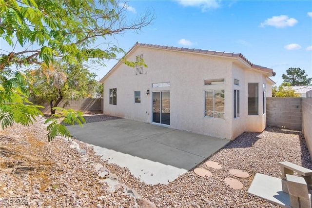 5307 Wild Orchid St, North Las Vegas, NV 89031 - rear view of house with stucco siding, a fenced backyard, a patio area, and a tiled roof