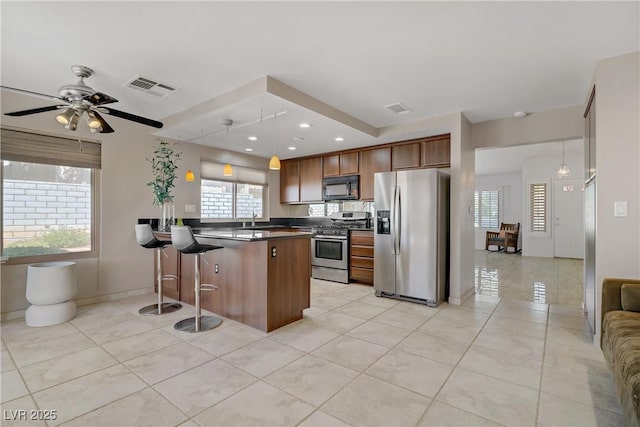 1219 Heather Oaks Way N, Las Vegas, NV 89031 - kitchen featuring stainless steel appliances, a peninsula, healthy amount of natural light, dark countertops, and recessed lighting