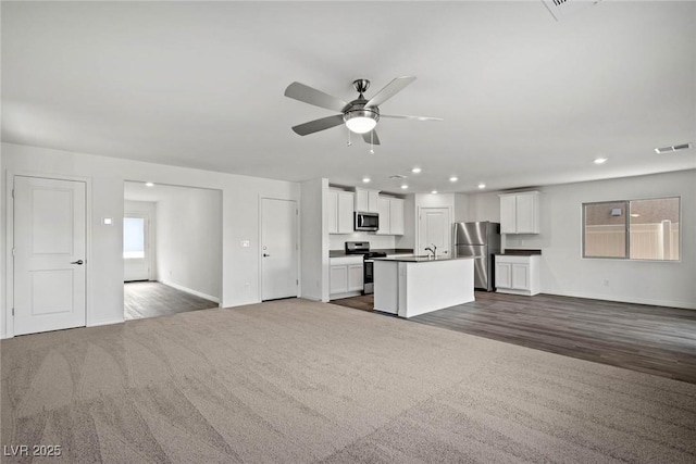 1704 Desert Path Ave, North Las Vegas, NV 89032 - unfurnished living room featuring a ceiling fan, dark colored carpet, baseboards, recessed lighting, and a sink