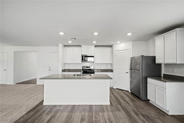 1704 Desert Path Ave, North Las Vegas, NV 89032 - kitchen with stainless steel appliances, dark wood-style flooring, white cabinetry, dark countertops, and recessed lighting