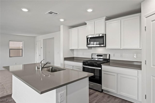 1704 Desert Path Ave, North Las Vegas, NV 89032 - kitchen with stainless steel appliances, a sink, dark countertops, white cabinets, and recessed lighting