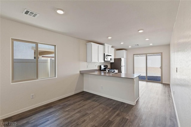 1716 Desert Path Ave, North Las Vegas, NV 89032 - kitchen featuring freestanding refrigerator, stove, stainless steel microwave, dark wood-type flooring, and recessed lighting