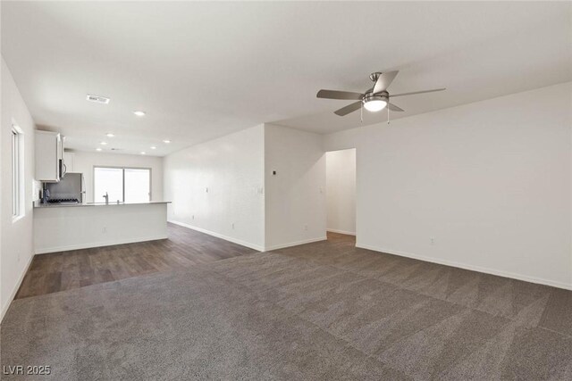 1716 Desert Path Ave, North Las Vegas, NV 89032 - unfurnished living room with dark carpet, ceiling fan, baseboards, recessed lighting, and a sink