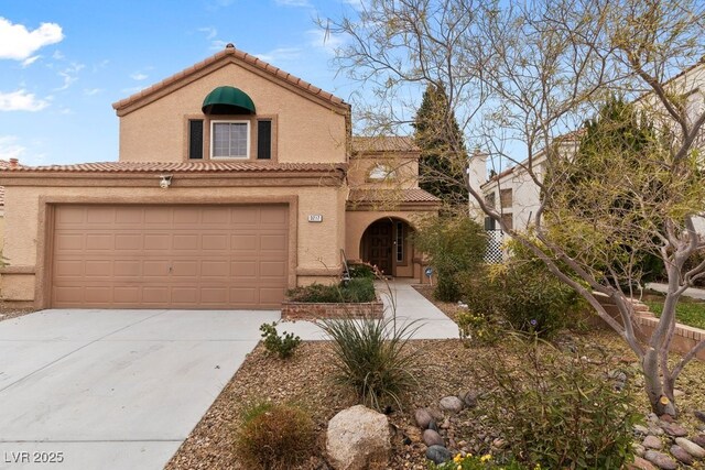 3217 Harbor Vista St, Las Vegas, NV 89117 - mediterranean / spanish home featuring concrete driveway, stucco siding, a tile roof, and a garage
