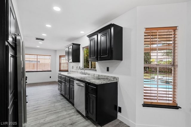 3217 Harbor Vista St, Las Vegas, NV 89117 - kitchen with dark cabinets, dishwasher, a sink, light wood-style flooring, and baseboards