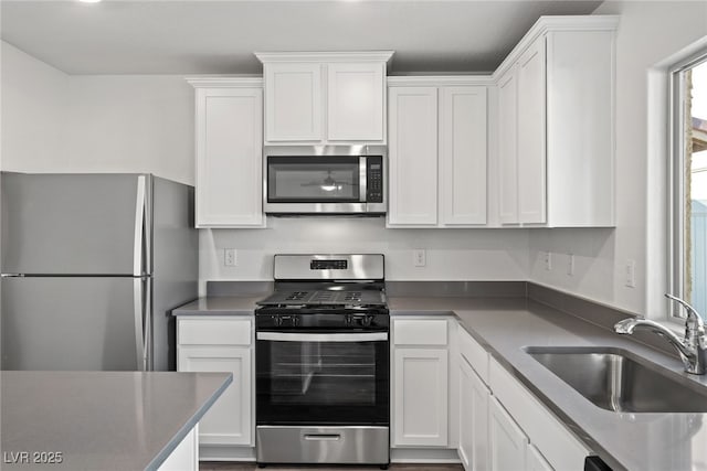1705 Desert Path Ave, North Las Vegas, NV 89032 - kitchen featuring stainless steel appliances, a sink, white cabinets, and dark countertops