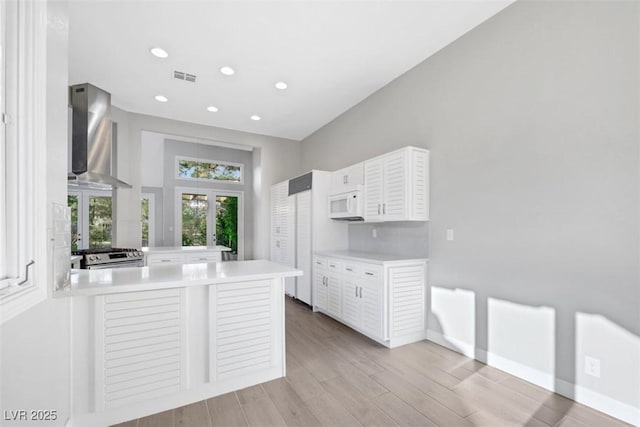 5008 Shoal Creek Cir, Las Vegas, NV 89113 - kitchen featuring white microwave, french doors, stainless steel gas range oven, a peninsula, and light countertops