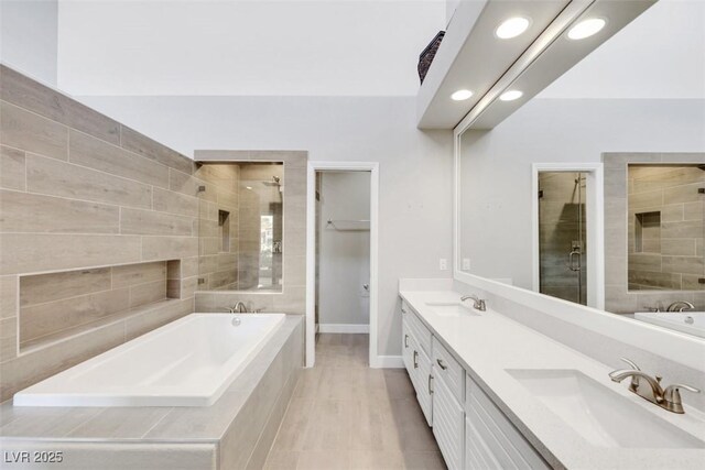 5008 Shoal Creek Cir, Las Vegas, NV 89113 - bathroom featuring tiled bath, tiled shower, double vanity, recessed lighting, and baseboards