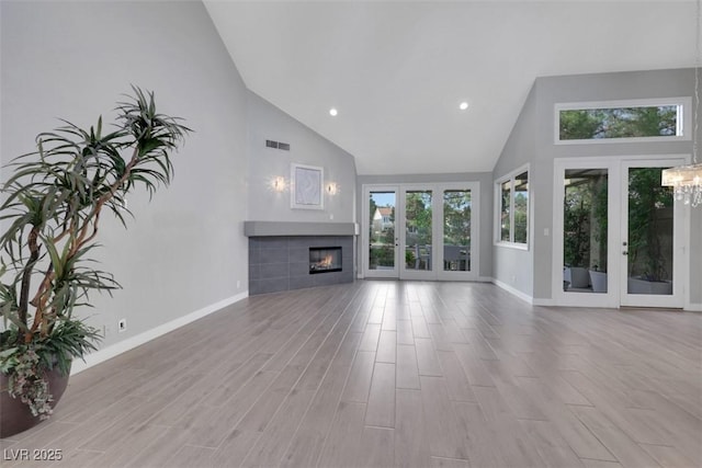5008 Shoal Creek Cir, Las Vegas, NV 89113 - unfurnished living room with high vaulted ceiling, baseboards, a fireplace, plenty of natural light, and a chandelier