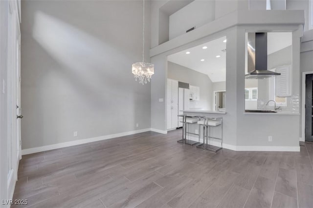 5008 Shoal Creek Cir, Las Vegas, NV 89113 - unfurnished living room with a chandelier, a towering ceiling, wood finished floors, baseboards, and recessed lighting