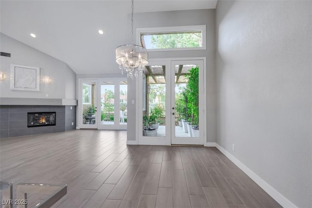 5008 Shoal Creek Cir, Las Vegas, NV 89113 - unfurnished living room with a chandelier, wood finished floors, a fireplace, french doors, and baseboards