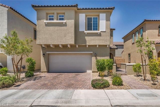 8055 Tank Loop St, Las Vegas, NV 89166 - mediterranean / spanish-style home featuring a garage, stucco siding, decorative driveway, and a gate