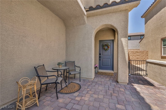 8055 Tank Loop St, Las Vegas, NV 89166 - view of exterior entry featuring stucco siding, a tiled roof, and a patio area