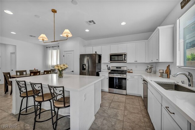 8055 Tank Loop St, Las Vegas, NV 89166 - kitchen with stainless steel appliances, healthy amount of natural light, a kitchen island, white cabinets, and recessed lighting