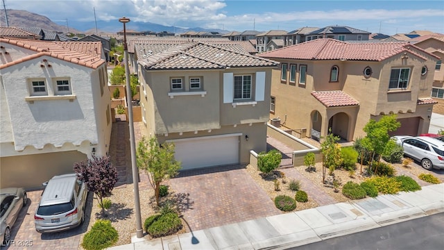 8055 Tank Loop St, Las Vegas, NV 89166 - mediterranean / spanish home featuring a residential view, stucco siding, an attached garage, decorative driveway, and a tile roof
