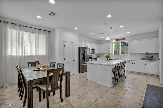 8055 Tank Loop St, Las Vegas, NV 89166 - kitchen with stainless steel appliances, white cabinets, light countertops, a center island, and recessed lighting