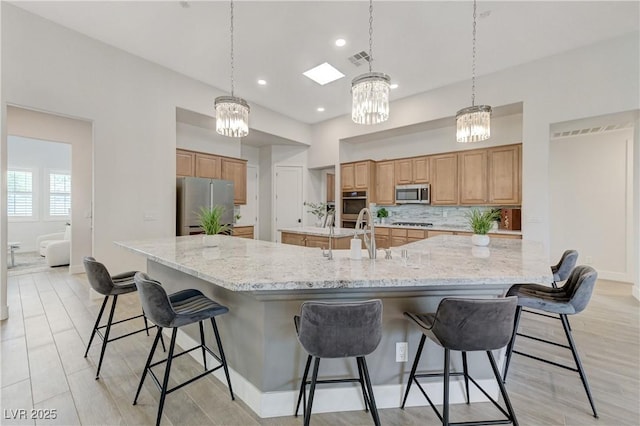 2168 Big Bar Dr, Henderson, NV 89052 - kitchen with stainless steel appliances, a chandelier, a sink, a spacious island, and a kitchen breakfast bar