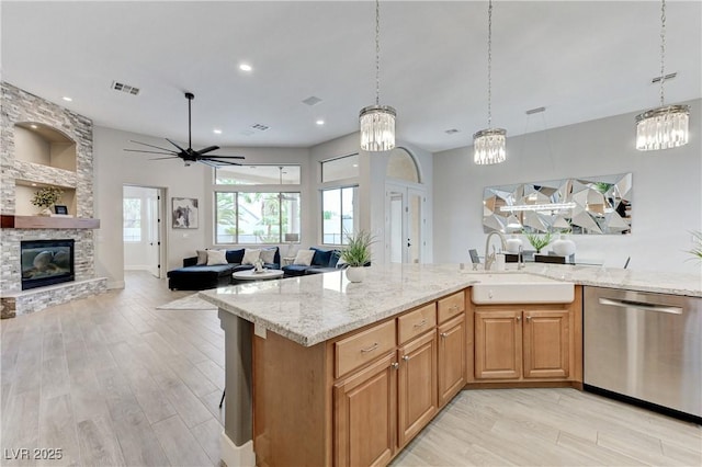 2168 Big Bar Dr, Henderson, NV 89052 - kitchen with stainless steel dishwasher, a sink, light stone counters, light wood-style flooring, and recessed lighting