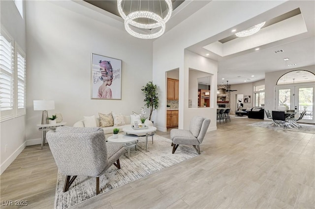 2168 Big Bar Dr, Henderson, NV 89052 - living area featuring light wood-style floors, a chandelier, recessed lighting, baseboards, and a towering ceiling
