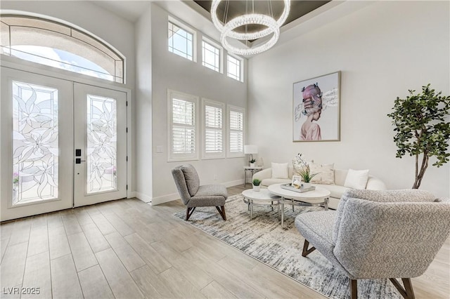 2168 Big Bar Dr, Henderson, NV 89052 - living room featuring a chandelier, wood finished floors, baseboards, and a high ceiling