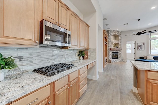 2168 Big Bar Dr, Henderson, NV 89052 - kitchen with stainless steel appliances, light brown cabinets, tasteful backsplash, and recessed lighting