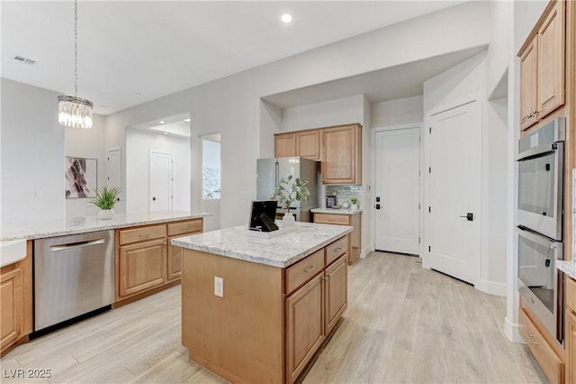 2168 Big Bar Dr, Henderson, NV 89052 - kitchen with appliances with stainless steel finishes, light wood-type flooring, a kitchen island, light stone counters, and pendant lighting