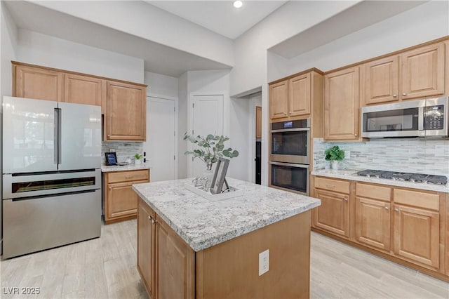 2168 Big Bar Dr, Henderson, NV 89052 - kitchen featuring appliances with stainless steel finishes, light wood finished floors, decorative backsplash, a center island, and recessed lighting