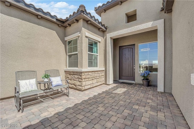 7258 W Le Baron Ave, Las Vegas, NV 89178 - view of exterior entry featuring stucco siding, a patio area, and stone siding