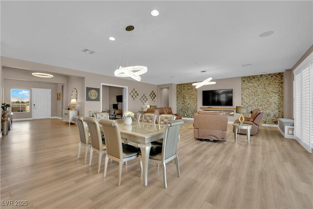 7258 W Le Baron Ave, Las Vegas, NV 89178 - dining room featuring a chandelier, wallpapered walls, light wood finished floors, baseboards, and an accent wall
