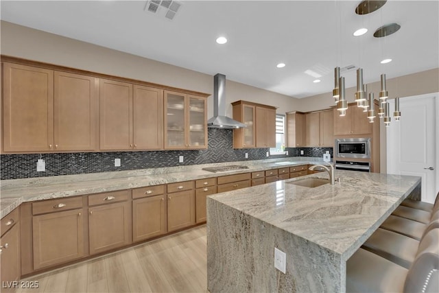 7258 W Le Baron Ave, Las Vegas, NV 89178 - kitchen with wall chimney range hood, a sink, stainless steel appliances, light wood-style flooring, and light stone countertops