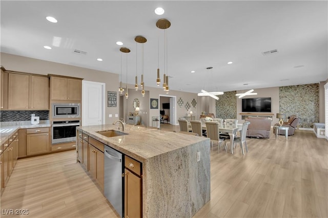 7258 W Le Baron Ave, Las Vegas, NV 89178 - kitchen featuring appliances with stainless steel finishes, a sink, open floor plan, light wood-style flooring, and recessed lighting