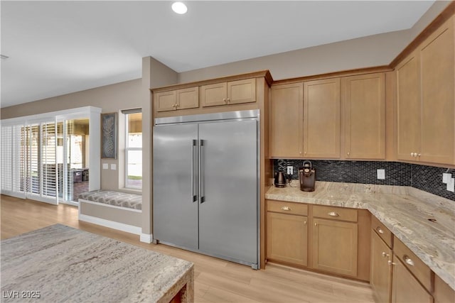 7258 W Le Baron Ave, Las Vegas, NV 89178 - kitchen with built in fridge, light wood-style floors, decorative backsplash, and light stone countertops