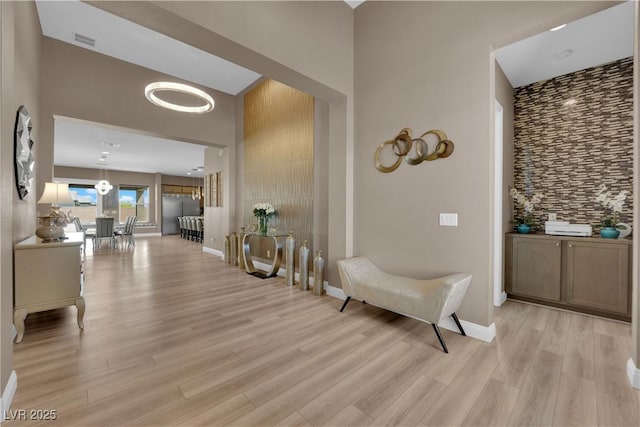 7258 W Le Baron Ave, Las Vegas, NV 89178 - corridor featuring light wood-style flooring, a high ceiling, baseboards, and a chandelier