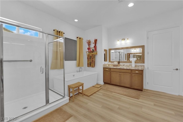 7258 W Le Baron Ave, Las Vegas, NV 89178 - bathroom with vanity, a shower stall, a garden tub, wood finished floors, and recessed lighting