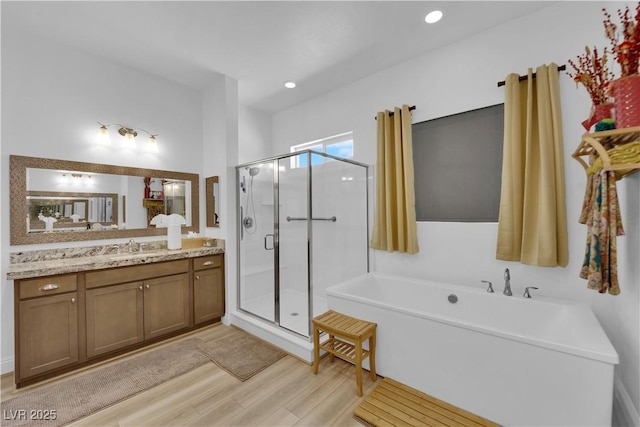 7258 W Le Baron Ave, Las Vegas, NV 89178 - full bathroom with wood finished floors, a soaking tub, vanity, and a shower stall