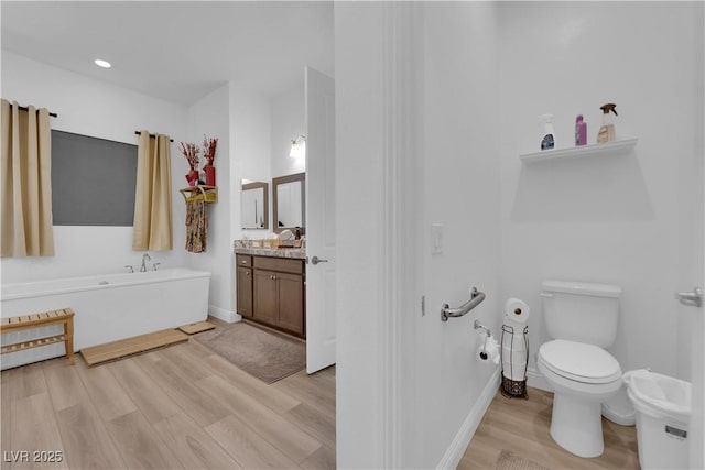 7258 W Le Baron Ave, Las Vegas, NV 89178 - bathroom with wood finished floors, a garden tub, vanity, baseboards, and toilet