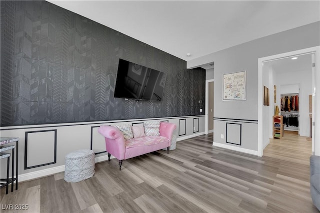 7258 W Le Baron Ave, Las Vegas, NV 89178 - living area with an accent wall, wallpapered walls, a decorative wall, wood finished floors, and wainscoting