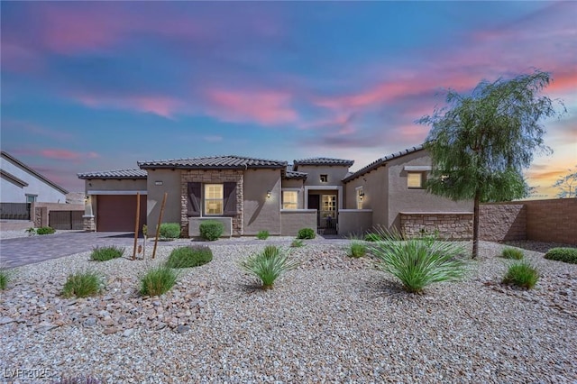 7258 W Le Baron Ave, Las Vegas, NV 89178 - mediterranean / spanish home featuring a tiled roof, stucco siding, an attached garage, driveway, and stone siding