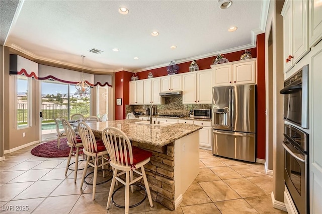 4719 Riva De Romanza St, Las Vegas, NV 89135 - kitchen with stainless steel appliances, light tile patterned floors, crown molding, decorative backsplash, and under cabinet range hood