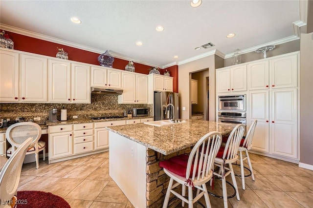 4719 Riva De Romanza St, Las Vegas, NV 89135 - kitchen with tasteful backsplash, light stone countertops, light tile patterned floors, appliances with stainless steel finishes, and crown molding