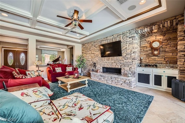 4719 Riva De Romanza St, Las Vegas, NV 89135 - living area featuring a ceiling fan, coffered ceiling, a stone fireplace, crown molding, and beamed ceiling