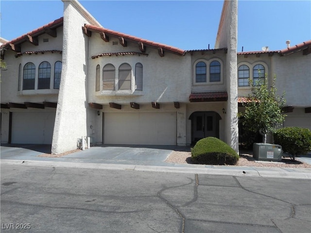 5006 Schumann Dr, Las Vegas, NV 89146 - mediterranean / spanish house with a garage, a tiled roof, and stucco siding