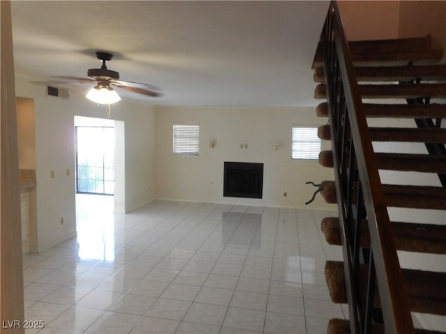 5006 Schumann Dr, Las Vegas, NV 89146 - unfurnished living room with light tile patterned flooring, stairs, a fireplace, and plenty of natural light