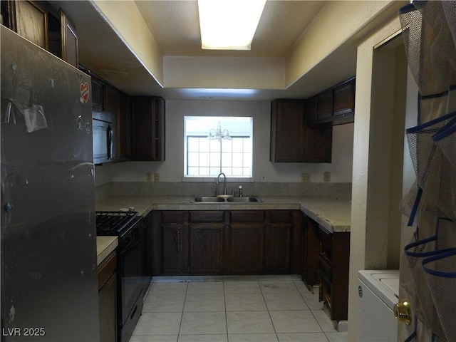 5006 Schumann Dr, Las Vegas, NV 89146 - kitchen featuring a sink, black appliances, a raised ceiling, light tile patterned floors, and light countertops