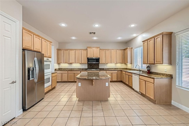 8305 Chapelle Ct, Las Vegas, NV 89131 - kitchen with stainless steel appliances, light brown cabinetry, a kitchen island, and recessed lighting