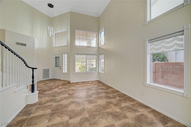 9772 Galahad Point Ct, Las Vegas, NV 89147 - entrance foyer featuring a high ceiling, baseboards, plenty of natural light, stairway, and stone finish flooring