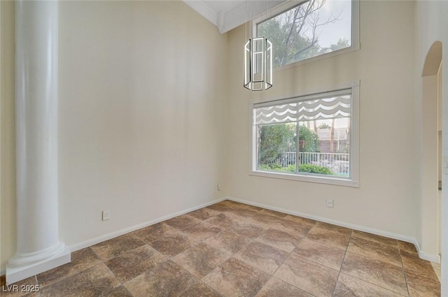 9772 Galahad Point Ct, Las Vegas, NV 89147 - unfurnished dining area with baseboards, stone finish flooring, decorative columns, and arched walkways