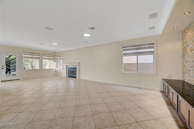 9772 Galahad Point Ct, Las Vegas, NV 89147 - unfurnished living room with crown molding, a glass covered fireplace, light tile patterned flooring, and recessed lighting